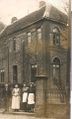 Die zur Schule gehörende Hausmeisterwohnung (1918). Zu sehen ist Schuldiener Hinrich de Jong mit seiner Familie.