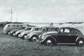 Mehrere Volkswagen am Deich, im Hintergrund links Norddeich Radio, rechts der Norddeicher Hafen (um 1960).
